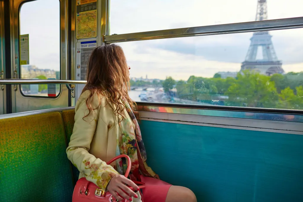 Ragazza che guarda la Torre Eiffel dal finestrino di un treno