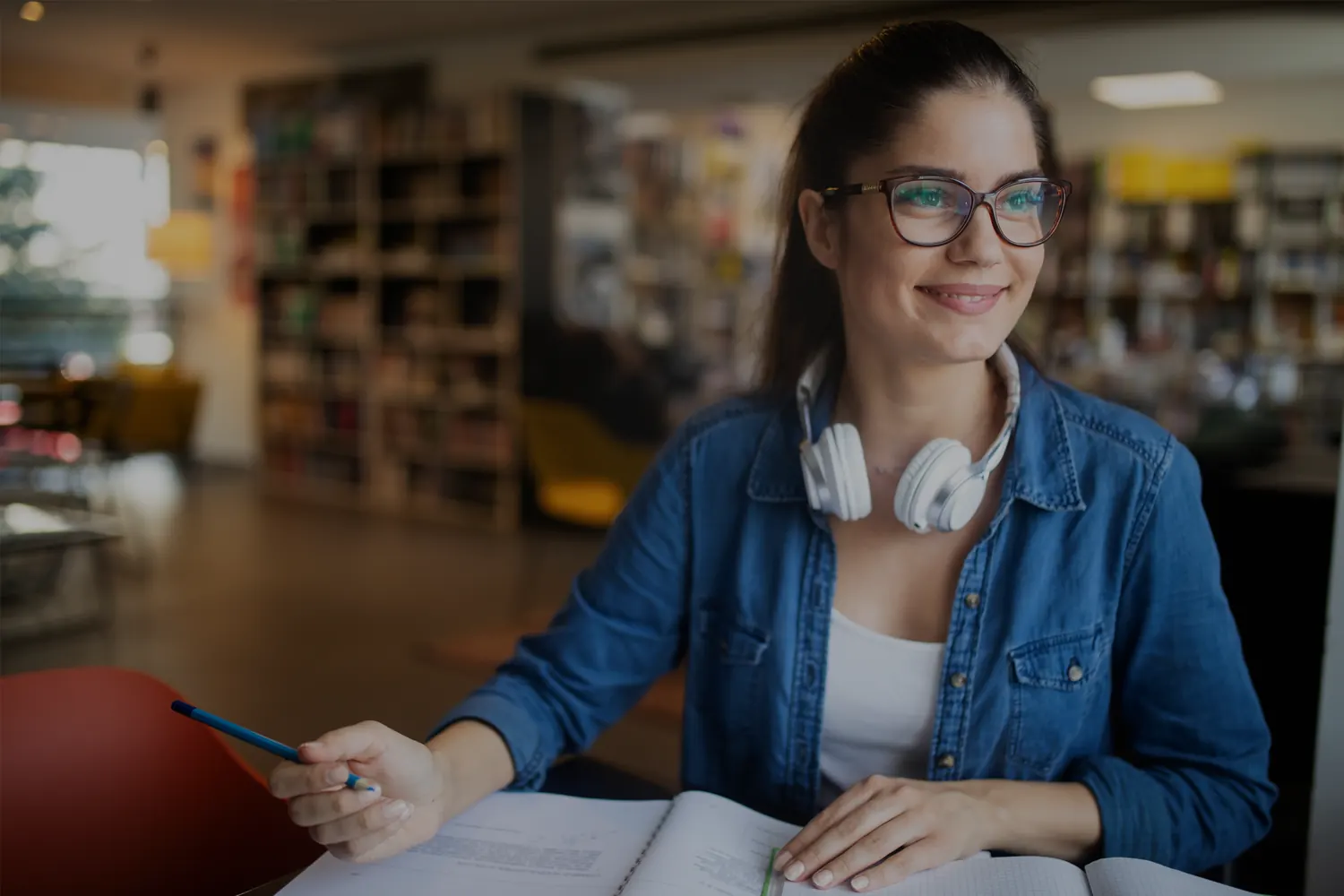 Studentessa con cuffie e libri durante lo studio